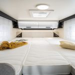 Heckbett mit Zusatzmatratze im Forster Wohnmobil T669 EB mit Kissen, Decken und einem großen Wandschrank