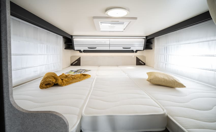 Heckbett mit Zusatzmatratze im Forster Wohnmobil T669 EB mit Kissen, Decken und einem großen Wandschrank
