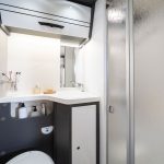 Bad mit geschlossener Dusche, Toilette, Waschbecken und Wandschrank im Forster Alkoven Wohnmobil A699 VB