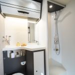 Bad mit offener Dusche, Toilette, Waschbecken und Wandschrank im Forster Alkoven Wohnmobil A699 VB